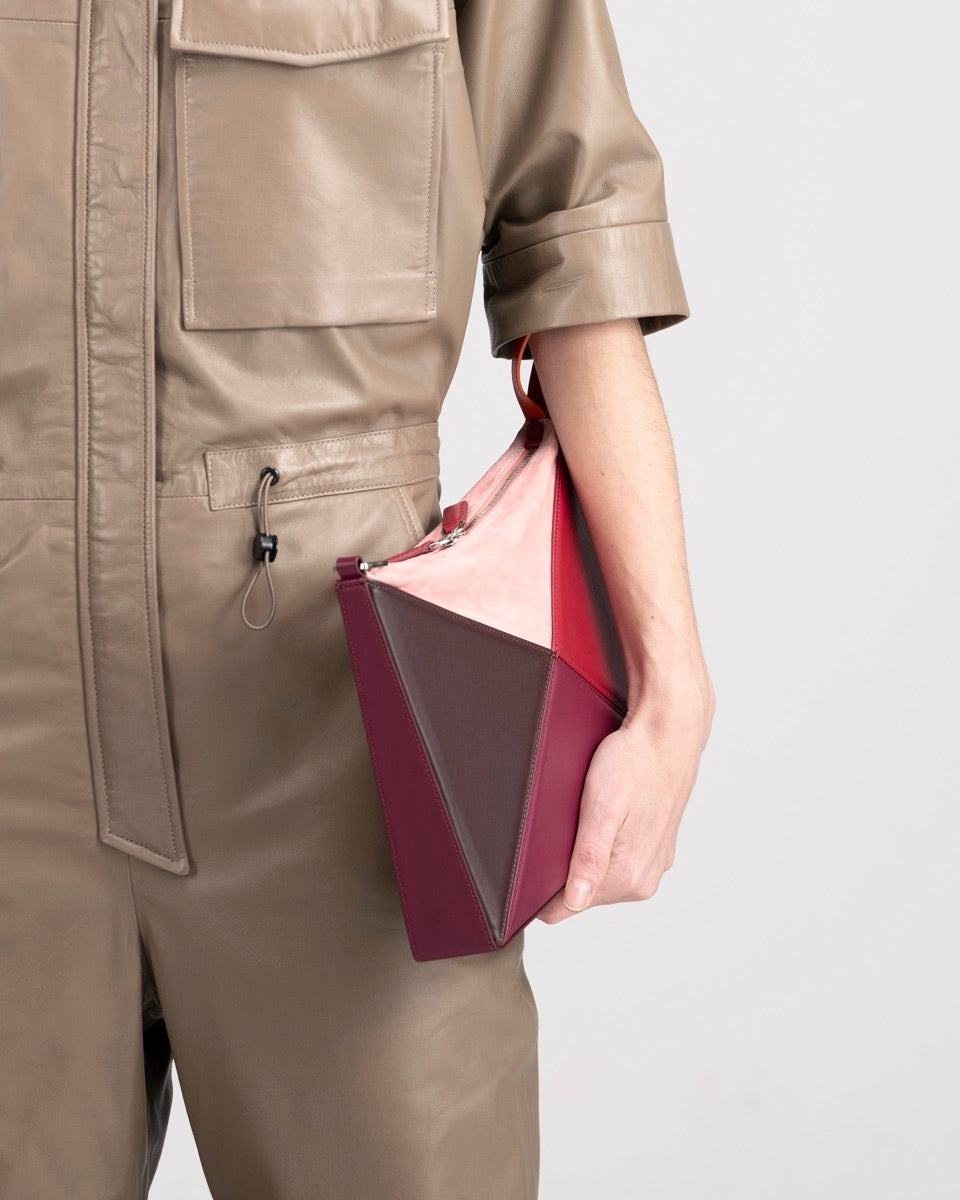 Flex Bag in Cranberry held flat under the arm as a clutch