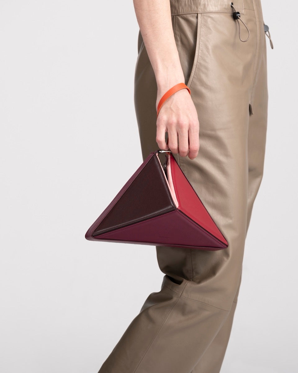 Flex Bag in Cranberry carried from the wrist by its handle, strap removed