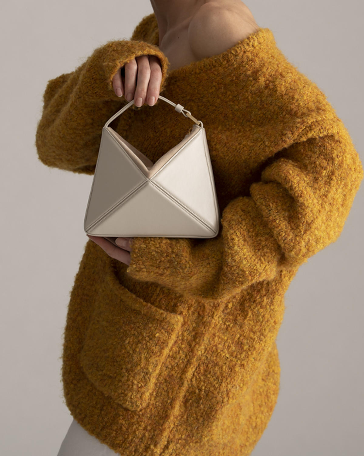 Mini Flex Bag in Dove carried in the hand by its top handle